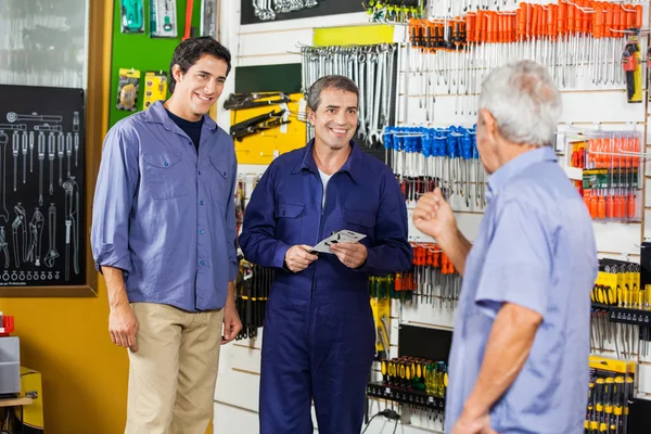 Lavoratore con i clienti nel negozio di hardware — Foto Stock