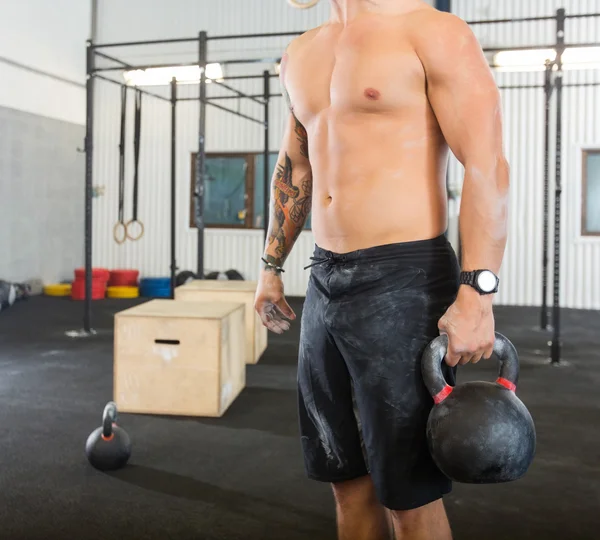 Männlicher Athlet trägt Kettlebell — Stockfoto