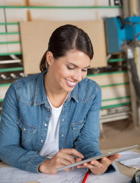 Falegname femminile utilizzando tavoletta digitale a tavola — Foto Stock