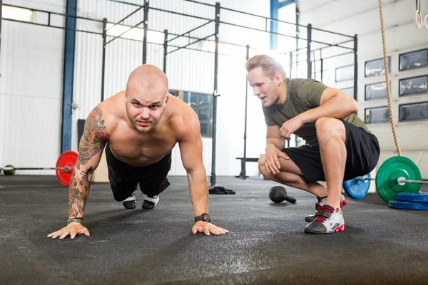 Trainer Assisting Man In Doing Pushups — Stock Photo, Image