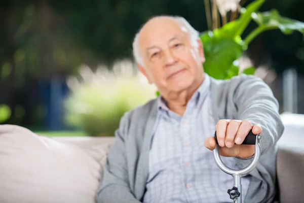 Retrato de homem sênior segurando cana de metal — Fotografia de Stock