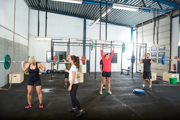 Trenér pomáhá sportovcům v Barbells zvedání — Stock fotografie