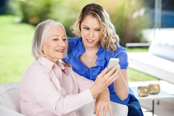 Sondotter bistå barnbarn med Smartphone — Stockfoto