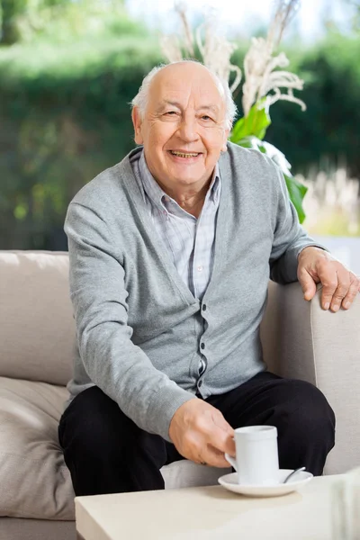 Feliz homem sênior tomando café no alpendre da casa de repouso — Fotografia de Stock