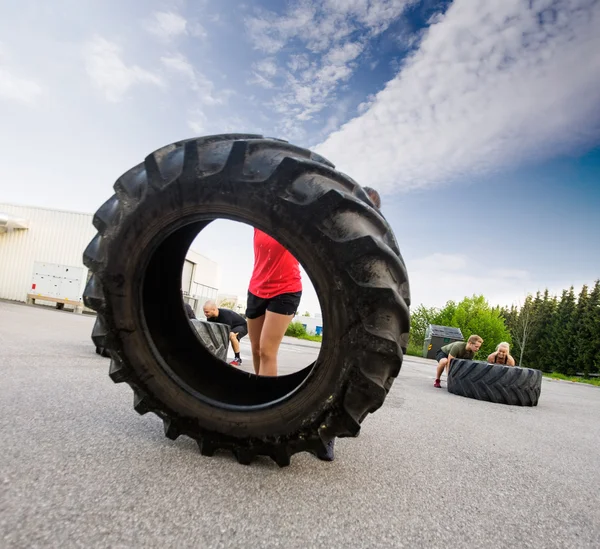 Atleta lançando grande pneu — Fotografia de Stock
