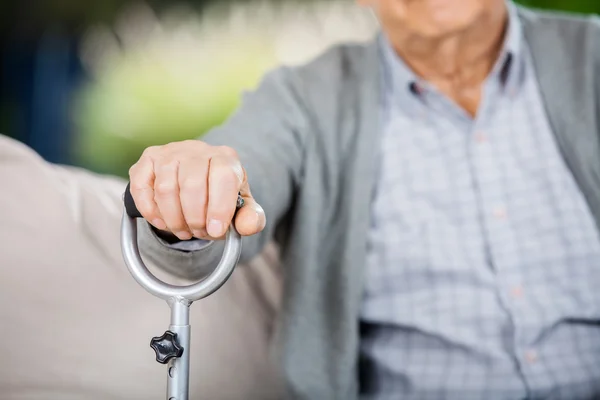 Bránice starší muž, který držel hůl kov — Stock fotografie