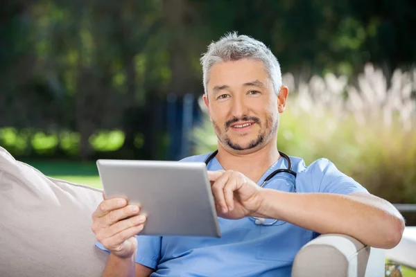 Cuidador masculino usando computador tablet — Fotografia de Stock