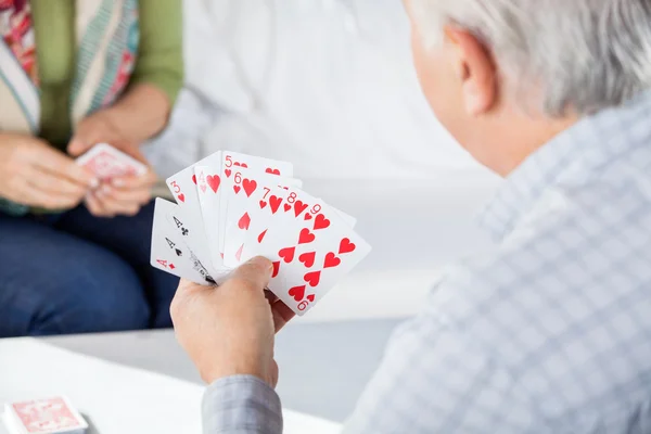 Senior Man speelkaarten met vrouwelijke vriend — Stockfoto