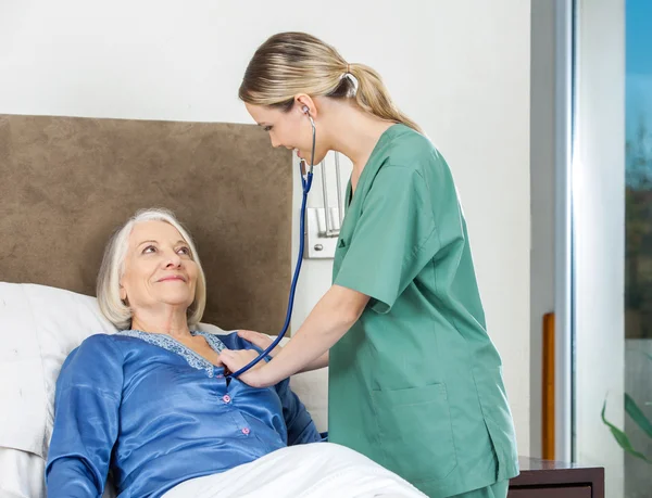 Gardienne examinant une femme âgée à la maison de soins infirmiers — Photo