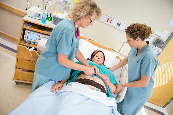 Enfermeiras preparando a mulher grávida para o monitor de frequência cardíaca fetal — Fotografia de Stock