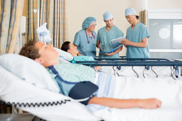 Enfermeras discutiendo tabla de pacientes después de la cirugía — Foto de Stock