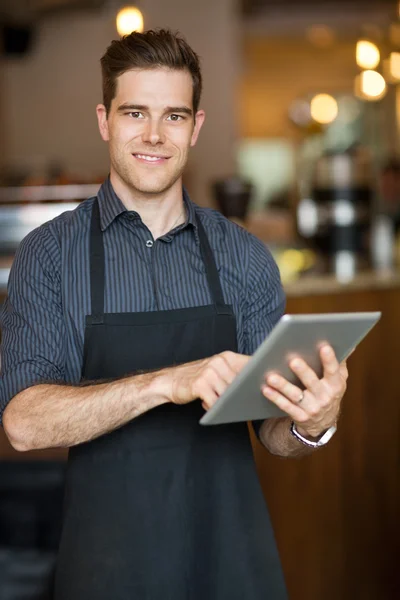 Владелец мужского пола держит цифровой планшет в кафе — стоковое фото