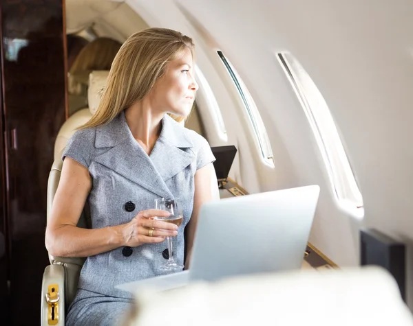透过私人飞机的窗口看的女商人 — 图库照片