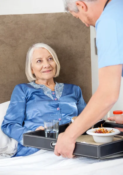 Hausmeister serviert der glücklichen Seniorin Frühstück — Stockfoto