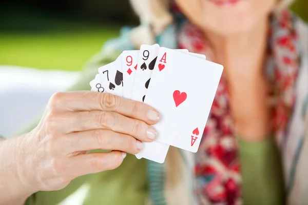 Старшая женщина показывает игральные карты — стоковое фото