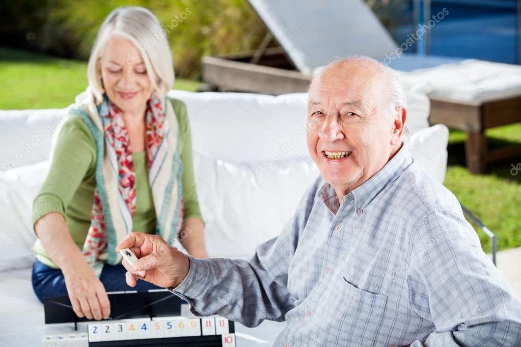 Happy Senior Man Playing Rummy With Woman