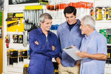 Pano donanım mağazasında müşterilerle bakarak işçi