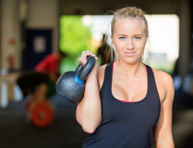 Kendine güvenen kadın atlet Kettlebell kaldırma