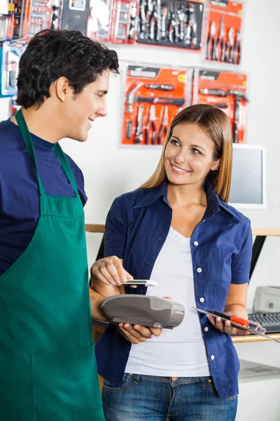 Vrouw betaling via Mobilephone In Hardware winkel maken — Stockfoto