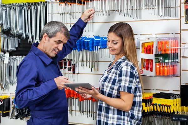 Cliente mostrando tablet digital para fornecedor na loja de ferragens — Fotografia de Stock