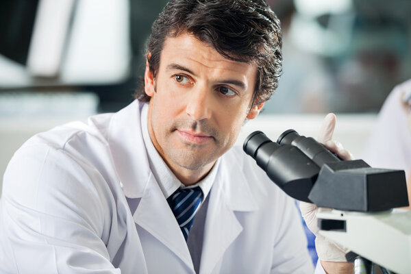 Scientist Using Microscope In Laboratory