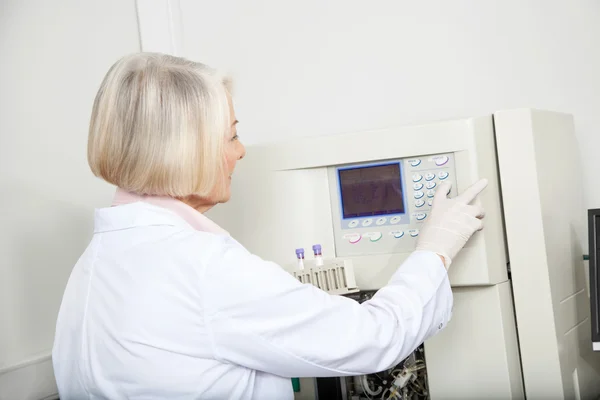 Scientifique avec des échantillons opérant l'analyseur en laboratoire — Photo