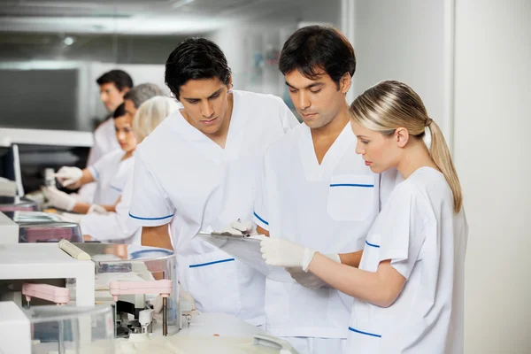 Technicians Discussing Over Clipboard — Stock Photo, Image