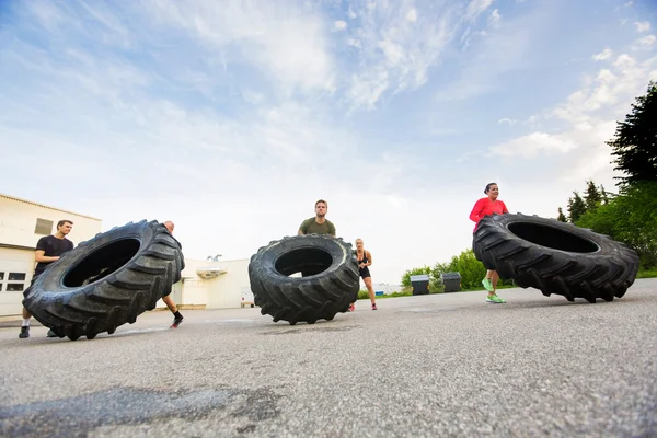 Atletas fazendo Tire-Flip Exercício — Fotografia de Stock