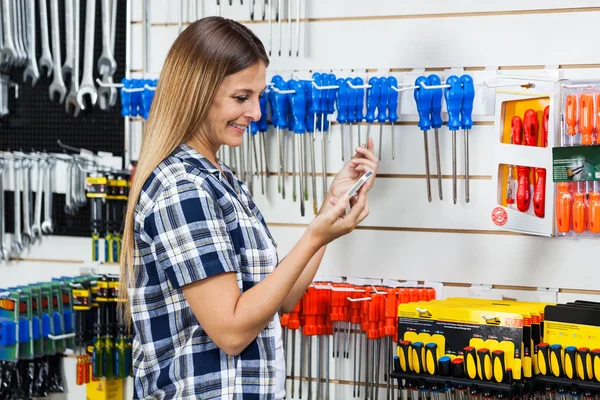 Kunde überprüft Informationen über Schraubendreher am Handy — Stockfoto