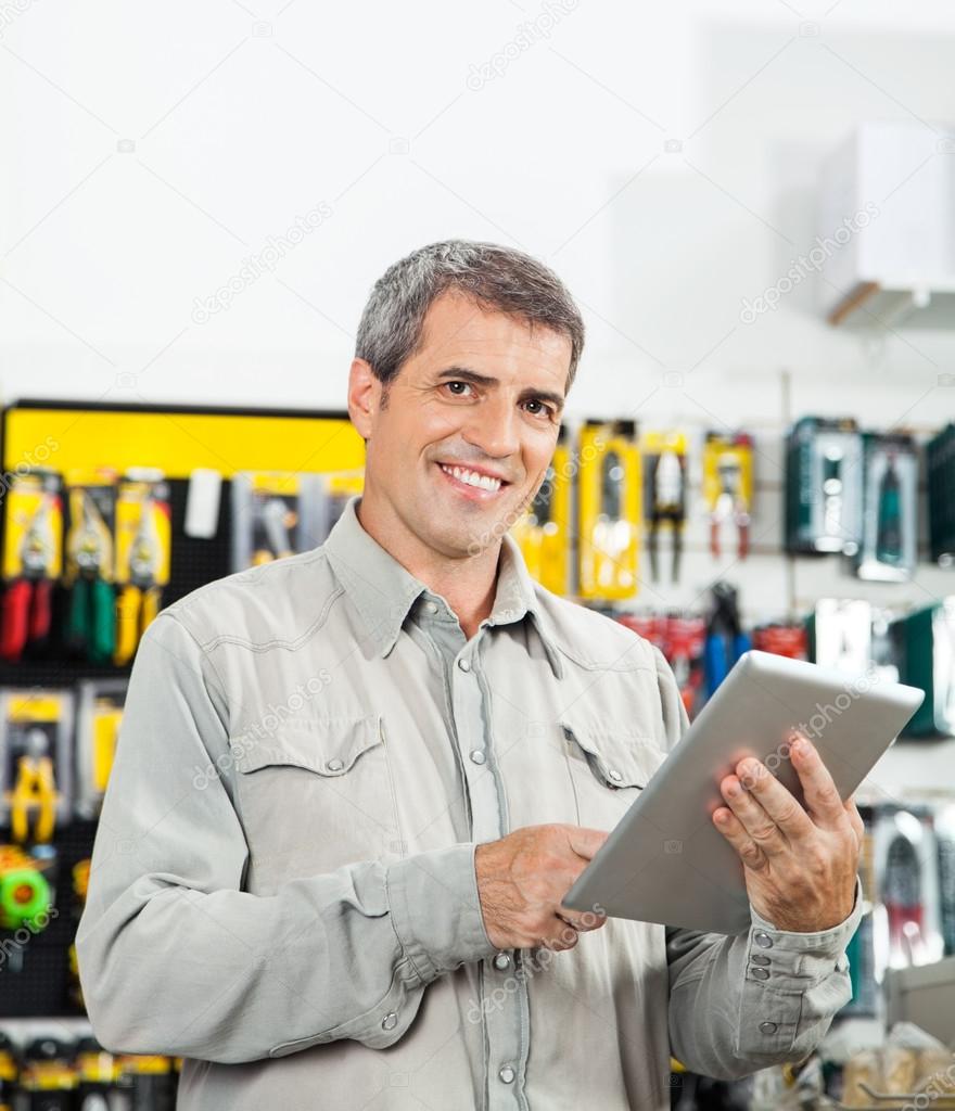 Confident Man Using Tablet Computer In Hardware Store