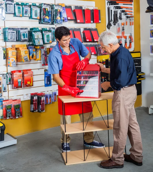 Vendedor que ayuda al hombre en la compra de herramientas en la tienda —  Fotos de Stock
