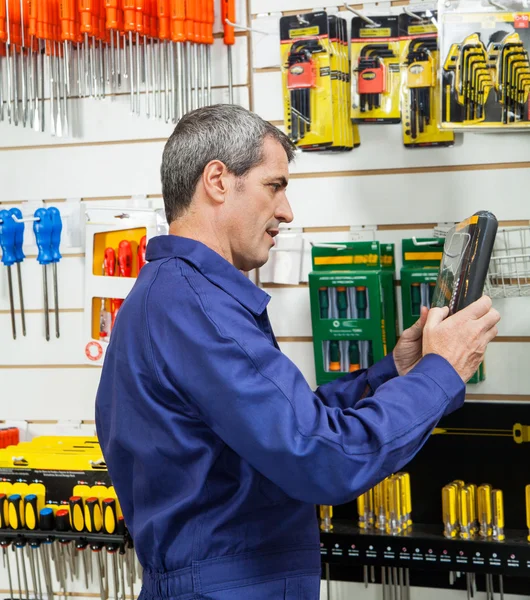 Trabajador mirando el producto embalado en la tienda de hardware — Foto de Stock