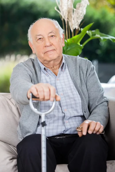 Portret starszego mężczyzny posiadających metalowe laski — Zdjęcie stockowe