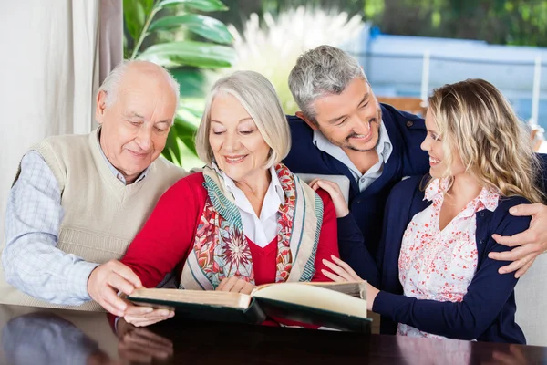 Feliz pareja mayor lectura libro con nietos en enfermería H — Foto de Stock