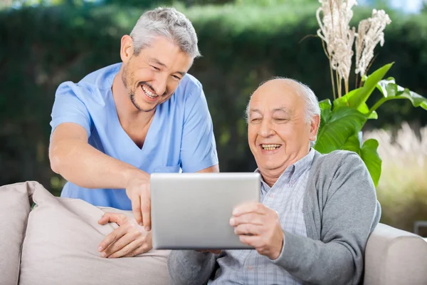 Mężczyzna pielęgniarka i starszy czlowiek smiechu podczas korzystania z cyfrowego tabletu — Zdjęcie stockowe