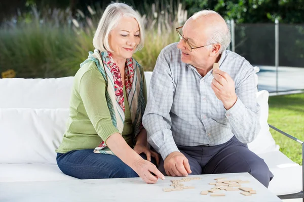 Glückliches Seniorenpaar spielt Dominosteine auf der Veranda — Stockfoto