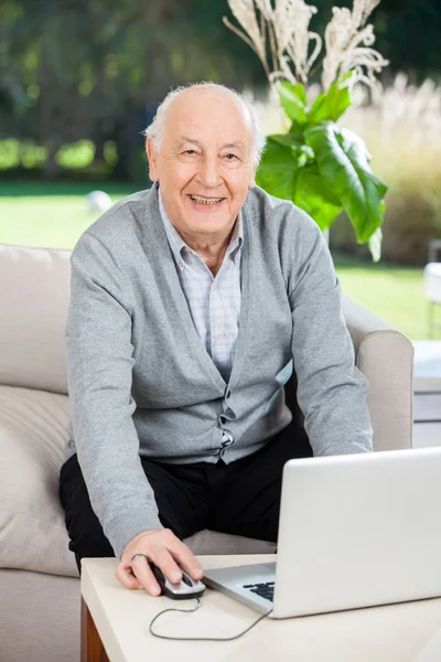 Homem sênior feliz usando laptop no alpendre da casa de repouso — Fotografia de Stock