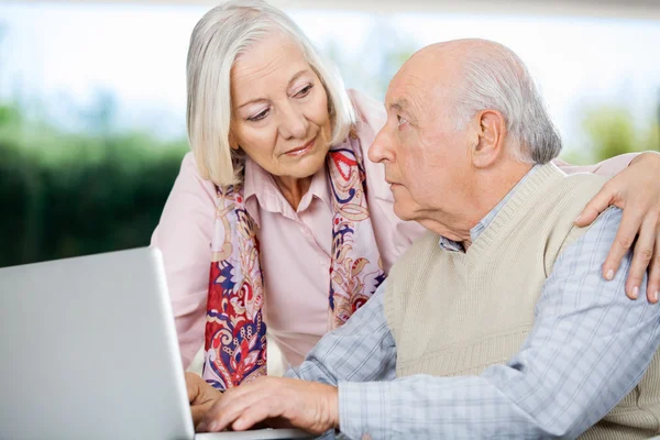 Senior Couple Looking At Each Other While Using Laptop — Stock Photo, Image