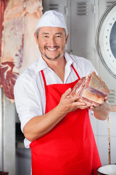 Carniceiro confiante mostrando pedaço de carne — Fotografia de Stock