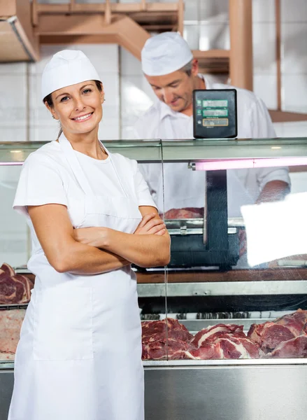 Carniceiro confiante com colega trabalhando na loja — Fotografia de Stock