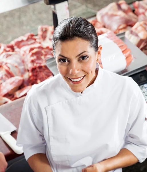 ディスプレイ キャビネットに立っている女性の自信を持っての肉屋 — ストック写真