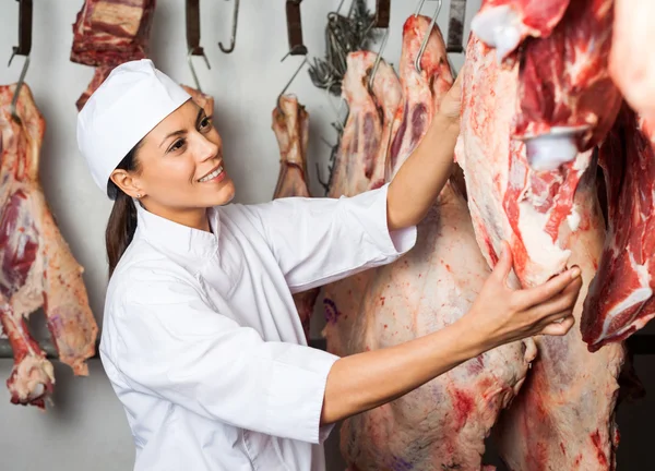 Carnicero probando calidad de la carne colgando —  Fotos de Stock