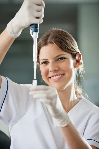 Wissenschaftlerin füllt Flüssigkeit ins Reagenzglas — Stockfoto