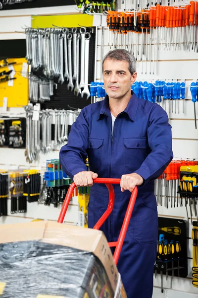 Carro de empuje del trabajador en la tienda de hardware — Foto de Stock