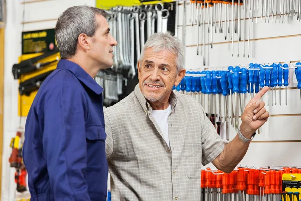 Klant wijzen terwijl kijken naar hardwareleverancier Shop — Stockfoto