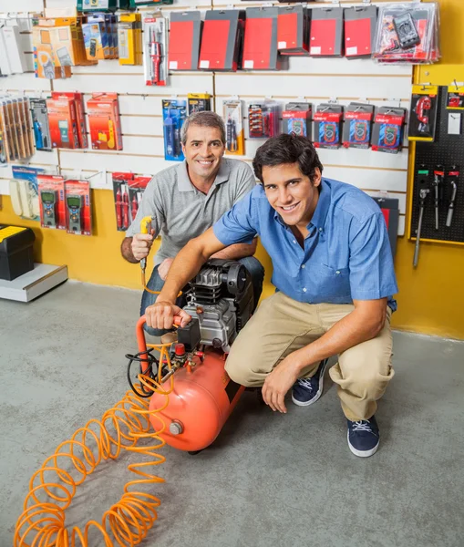 Otec a syn drží vzduchový kompresor v úložišti — Stock fotografie