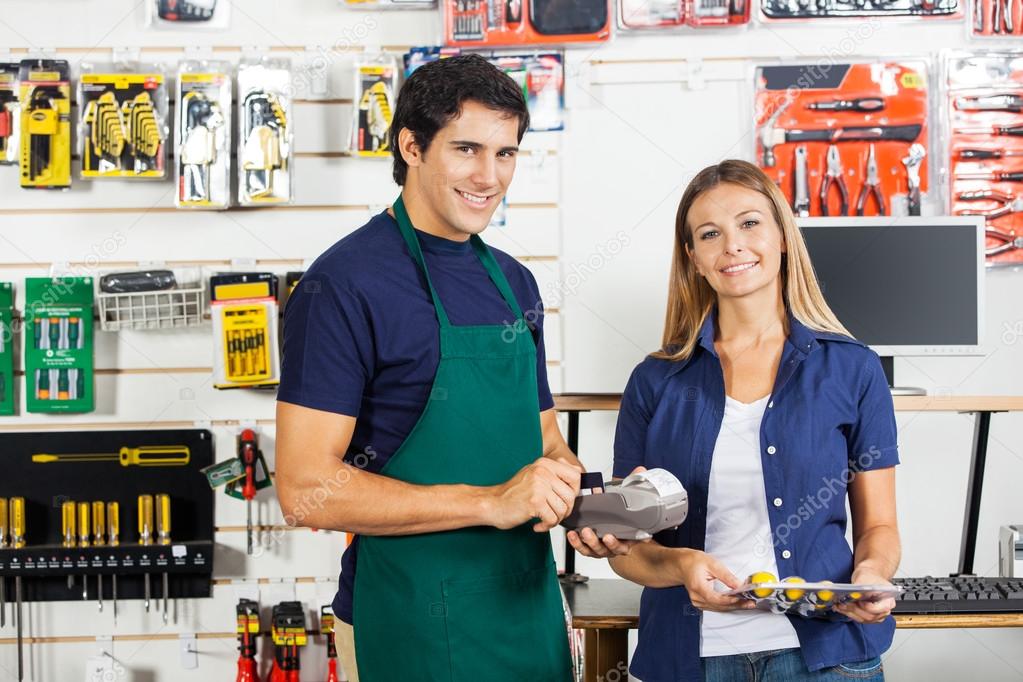 Woman Holding Screwdriver Set With Worker Swiping Credit Card