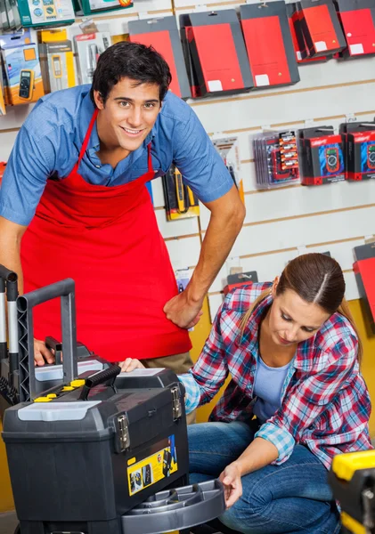 Vendeur avec le client examinant le cas d'outil en magasin — Photo