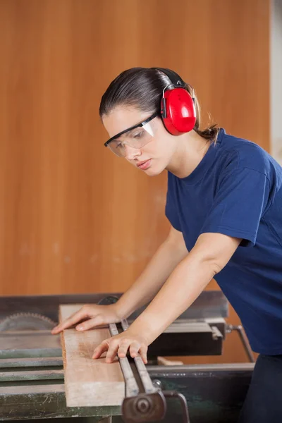 Carpinteiro feminino corte de madeira com tablesaw — Fotografia de Stock