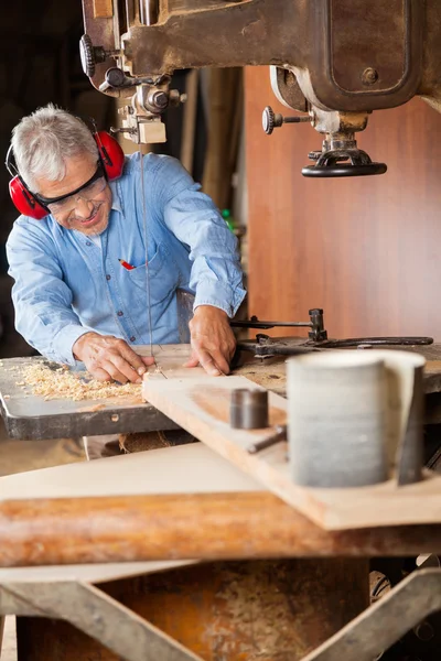 Falegname che utilizza la sega a nastro per tagliare il legno — Foto Stock